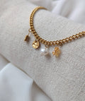 Bracelet doré en acier inoxydable avec breloques dorées et perle d'eau douce